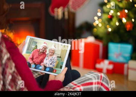 Redhead using tablet computer à Noël à la maison dans le salon Banque D'Images