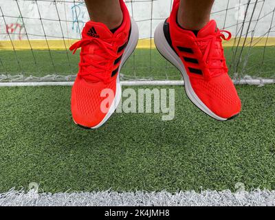 Tyumen, Russia-13 août 2022: Nouvelles chaussures de course à pied Adidas, couleur corail orange, course eq21. Banque D'Images