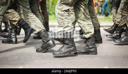 Des soldats en marche dans des bottes militaires Banque D'Images