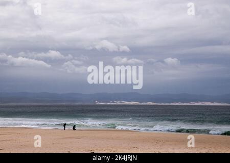 Magnifique océan pittoresque multicolore avec brise-roches, ciel bleu avec nuages texturés et plage de sable doux Banque D'Images