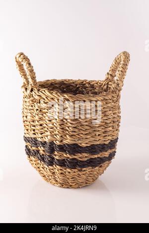 Panier d'herbe marine. Boîte en osier d'une tige. Récipient en matériaux naturels pour le stockage et la décoration dans la maison. Panier sur fond blanc. Banque D'Images