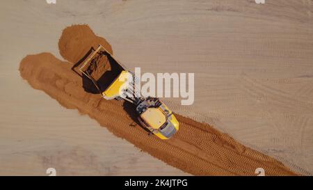 Travaux de construction de routes. Un bulldozer sur un chantier, préparant le sol d'une route, nivelant le sol. Varsovie, Pologne. Vue de dessus de l'antenne. Photo de haute qualité Banque D'Images