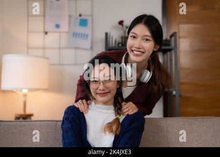 Deux femmes asiatiques ayant une activité agréable et animée dans le salon sur le canapé dans un intérieur confortable Banque D'Images