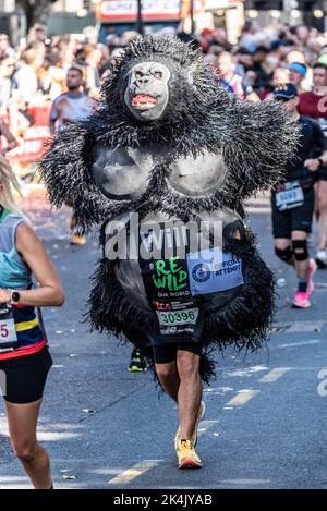 Will Highfield en course au TCS London Marathon 2022, sur Tower Hill Road, City of London, Royaume-Uni. Portant un costume de gorille pour Re-Wild Our World Banque D'Images