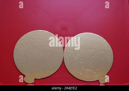 Deux bulles de discours dorées sur fond rouge texturé. Banque D'Images