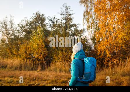 Tourisme avec marche à dos dans la forêt d'automne. Femme randonnée dans la nature d'automne Banque D'Images