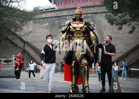 XI'AN, CHINE - 1 OCTOBRE 2022 - les touristes posent avec un haut de 2,7 mètres de haut mecha 'Warrior' croisière à la porte de Yongning de Xi 'an City Wall à Xi 'an, Shaanxi Banque D'Images