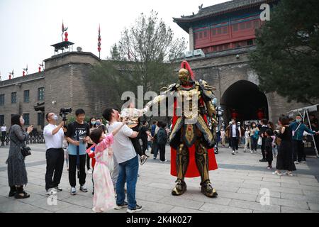XI'AN, CHINE - 1 OCTOBRE 2022 - les touristes posent avec un haut de 2,7 mètres de haut mecha 'Warrior' croisière à la porte de Yongning de Xi 'an City Wall à Xi 'an, Shaanxi Banque D'Images