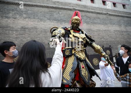 XI'AN, CHINE - 1 OCTOBRE 2022 - les touristes posent avec un haut de 2,7 mètres de haut mecha 'Warrior' croisière à la porte de Yongning de Xi 'an City Wall à Xi 'an, Shaanxi Banque D'Images