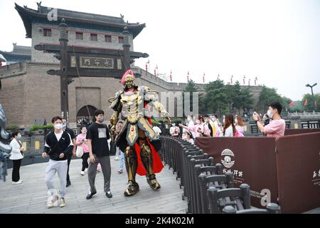 XI'AN, CHINE - 1 OCTOBRE 2022 - les touristes posent avec un haut de 2,7 mètres de haut mecha 'Warrior' croisière à la porte de Yongning de Xi 'an City Wall à Xi 'an, Shaanxi Banque D'Images