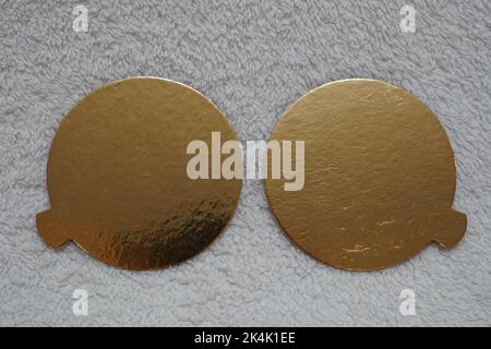 Deux bulles de discours dorées sur fond rouge texturé. Banque D'Images