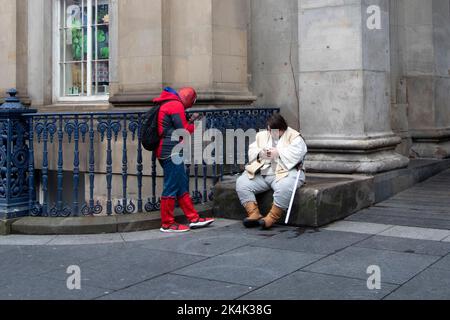 Spider man et OBI-wan Kenobi vérifient leurs téléphones, à l'extérieur de la Gallery of Modern Art, Glasgow, Glasgow, Écosse, Royaume-Uni Banque D'Images