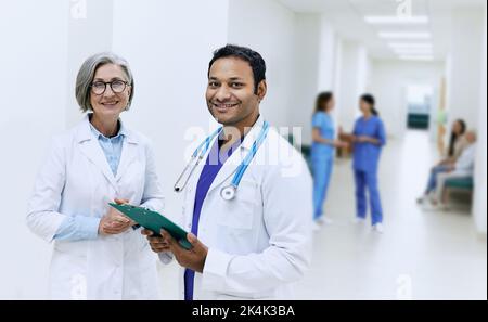 Groupe de médecins de nationalité différente en uniforme médical debout ensemble dans la salle d'hôpital Banque D'Images