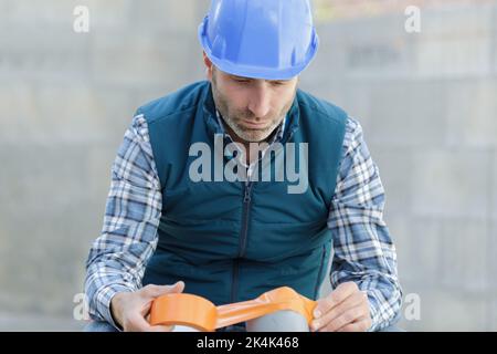 arrosage par un travailleur sur le chantier de construction du pipeline du système de chauffage urbain Banque D'Images