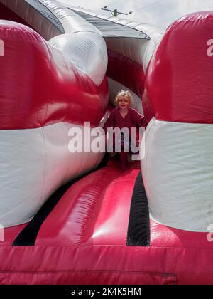 Jeune enfant glissant sur une grande glissade, Royaume-Uni Banque D'Images