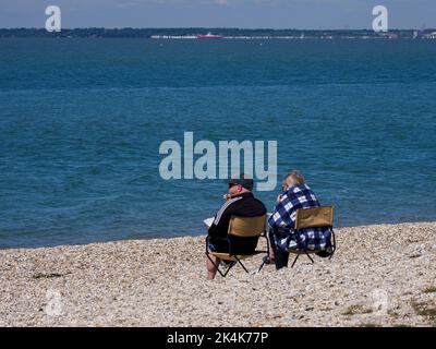 Couple d'âge mûr assis sur la plage de Lee-on-the-Solent, déjeuner, Hampshire, Royaume-Uni Banque D'Images