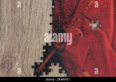 Pièces de puzzle rouges sur table en bois avec espace pour le texte. Idée de concept de scie sauteuse. Banque D'Images