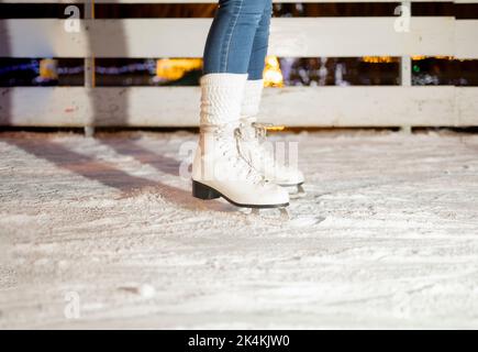 Jambes de femme en patins à glace blancs Banque D'Images