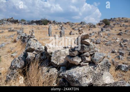 Cairn pile de pierres cailloux cairn sur la route en montagne. Concept d'équilibre et d'harmonie. Art méditatif de l'empilage de pierres. Mise au point sélective. Banque D'Images