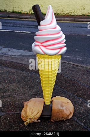 Un modèle de publicité de glace stabilisé par des sacs de sable à l'extérieur d'un magasin dans la rue principale à Mallaig, Morar, Écosse, Royaume-Uni. Banque D'Images