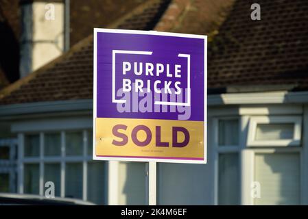 Un panneau 'Violet Brick' en ligne agents immobiliers 'Stop' à l'extérieur d'une maison de banlieue à Shepperton Surrey Angleterre Royaume-Uni Banque D'Images
