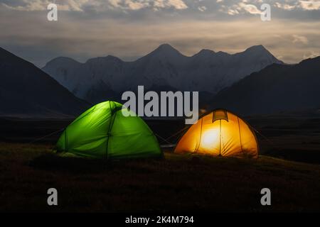 Tentes colorées avec des lumières sous le paysage de lune de la vallée de Sary Jaz la nuit, Kirghizistan, montagnes Tien Shan Banque D'Images