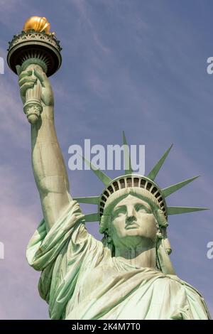 Gros plan du visage, de la couronne et de la main tenant la torche de la Statue de la liberté par temps ensoleillé Banque D'Images