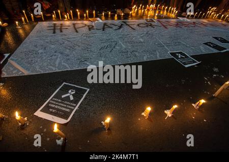 Palu, Sulawesi central, Indonésie. 3rd octobre 2022. Les résidents ont offert des prières et allumé des bougies comme une forme de tristesse pour l'incident des émeutes au championnat de football en Indonésie entre AREMA Malang et Persebaya Surabaya. L'incident a porté un coup sévère aux footballeurs du monde entier. 125 personnes auraient été tuées à la suite de l'incident. (Image de crédit : © Adi Pranata/ZUMA Press Wire) Banque D'Images