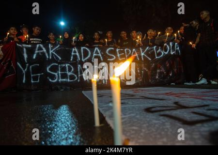 Palu, Sulawesi central, Indonésie. 3rd octobre 2022. Les résidents ont offert des prières et allumé des bougies comme une forme de tristesse pour l'incident des émeutes au championnat de football en Indonésie entre AREMA Malang et Persebaya Surabaya. L'incident a porté un coup sévère aux footballeurs du monde entier. 125 personnes auraient été tuées à la suite de l'incident. (Image de crédit : © Adi Pranata/ZUMA Press Wire) Banque D'Images