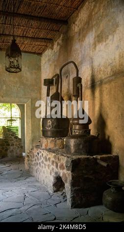 Gros plan d'un authentique distillateur antique en cuivre, dans un ancien bâtiment, sur la pierre, la patine sur les murs et le plafond Banque D'Images