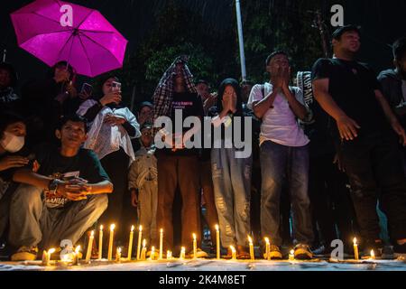 Palu, Sulawesi central, Indonésie. 3rd octobre 2022. Les résidents ont offert des prières et allumé des bougies comme une forme de tristesse pour l'incident des émeutes au championnat de football en Indonésie entre AREMA Malang et Persebaya Surabaya. L'incident a porté un coup sévère aux footballeurs du monde entier. 125 personnes auraient été tuées à la suite de l'incident. (Image de crédit : © Adi Pranata/ZUMA Press Wire) Banque D'Images