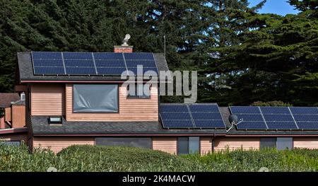 Panneaux solaires installés et fonctionnant sur le toit de la résidence, système d'énergie solaire, Sitka Spruce grove en arrière-plan, Californie. Banque D'Images