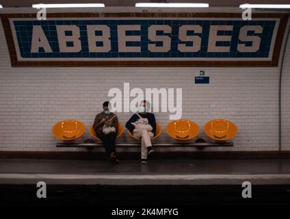 Deux hommes dans des masques assis sur les chaises et attendant le métro à Paris, France Banque D'Images