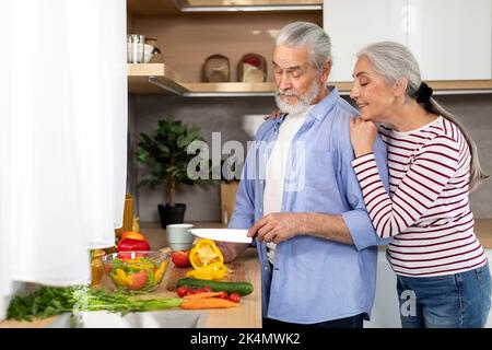 Concept de recettes de famille. Un couple de personnes âgées heureux cuisinez de la nourriture pour le déjeuner à la maison Banque D'Images