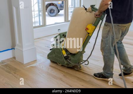 Lors de la construction d'une maison récemment construite, vous trouverez qu'une ponceuse de plancher est utilisée pour meuler un parquet en bois Banque D'Images