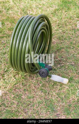Tuyau de jardin vert pelouse nouvel équipement de jardinage enroulé Banque D'Images