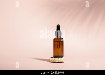 Flacons compte-gouttes en verre ambré pour le sérum sur pierre avec ombres à feuilles de palmier Banque D'Images