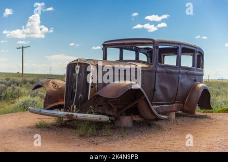 Une voiture antique de Studebaker abîmé et rouillé, assise le long de l'ancienne route 66 Highway. Banque D'Images
