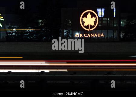 Le logo d'Air Canada est illuminé sur un panneau, vu de nuit le long d'une route très fréquentée; Air Canada est le transporteur national et la plus grande compagnie aérienne du Canada. Banque D'Images