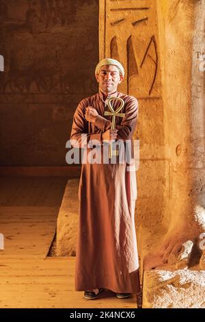 Abu Simbel, Assouan, Égypte. 23 février 2022. Gardien tenant une grande clé en forme d'Ankh dans le Grand Temple de Ramesses II Banque D'Images