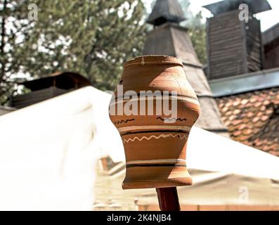 Un vieux pot en argile ukrainienne est séché sur un bâton de bois. Banque D'Images