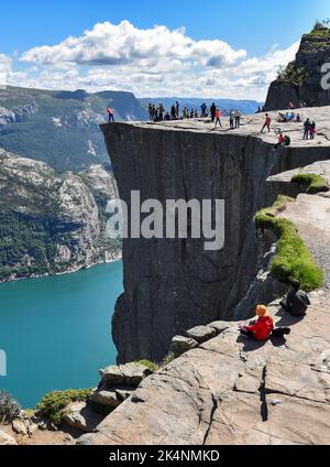 Touristes visitant le sommet de Preikestolen ou 'le rocher de Pulpit' , une falaise populaire au-dessus du Lysefjorden en Norvège. Banque D'Images