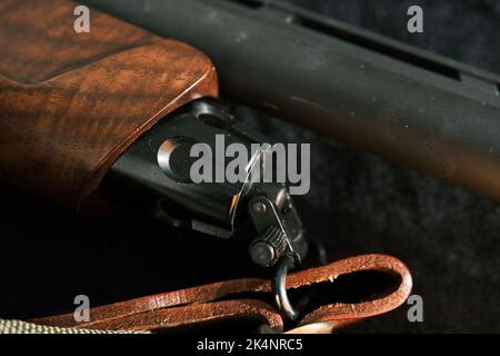 shell magazine dans le canon d'un long fusil sur fond sombre avec ceinture en cuir. Banque D'Images