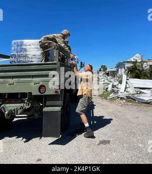 Port Charlotte, États-Unis. 02nd octobre 2022. Les soudeurs de la Garde nationale de l'Armée de Floride distribuent de l'eau embouteillée aux résidents bloqués à la suite de l'ouragan de catégorie 4 Ian, à 2 octobre 2022, à Port Charlotte, en Floride. Crédit : SSTGT. Debra Cook/US Air Force/Alamy Live News Banque D'Images