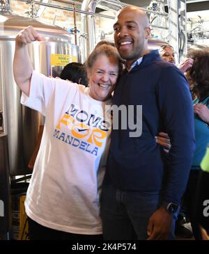 Racine, Wisconsin, États-Unis. 3rd octobre 2022. LT. GOV. MANDELA BARNES du Wisconsin, qui se présente comme le candidat démocrate contre le sénateur américain sortant Ron Johnson (R-Oshkosh) à l'élection de 8 novembre, salue les partisans et parle des droits à l'avortement à Littleport Brewing Co. À racine, Wisconsin lundi 3 octobre 2022. Cette étape s'inscrivait dans le cadre de sa tournée de campagne « Ron Against Roe », qui a mis en lumière la décision controversée de la Cour suprême sur l'avortement. Il s'est présenté avec un groupe appelé 'moms for Mandela' et pose pour une photo avec CHRISTINE FLYNN, membre du groupe et copropriétaire des affaires Banque D'Images