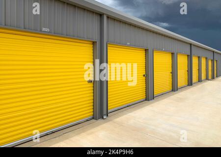 Extérieur d'un entrepôt commercial avec portes à roulettes jaunes, garages, installations de stockage autonomes Banque D'Images