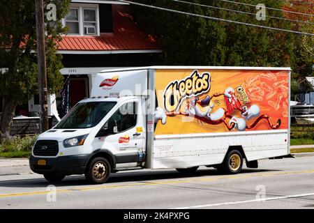 Un camion de livraison blanc Frito Lay Good Fun avec une publicité pour Cheetos sur le côté qui traverse le spéculateur, NY USA Banque D'Images