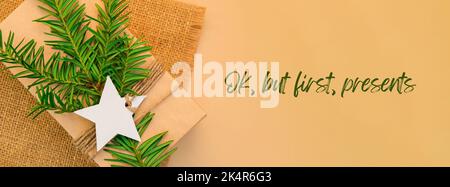 OK, mais d'abord, présente inspiration blague citation phrase Box avec les cadeaux du nouvel an, enveloppé dans le papier artisanal et décoré avec branche de sapin. Concept de vacances et de cadeaux. Un Noël vert alternative fait main et écologique présente une bannière zéro déchet Banque D'Images