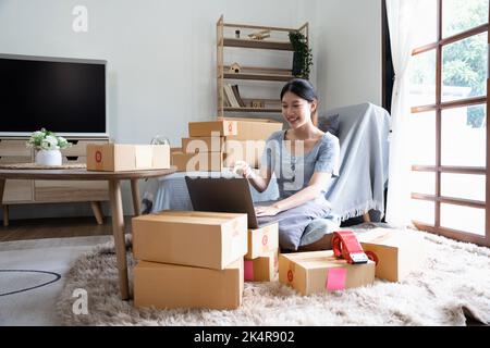 Les propriétaires d'entreprises asiatiques qui utilisent un ordinateur portable pour communiquer avec leurs clients via les appels vidéo. En ligne pendant que vous travaillez au bureau à domicile Banque D'Images