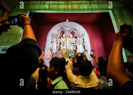 Kolkata, Inde. 03rd octobre 2022. Les gens prennent des photos devant l'entrée de différents Pandals (lieux temporaires de culte). Sandhi Puja est considéré comme le temps de jonction entre les huitième et neuvième jours de Durga Puja quand 108 Diyas sont illuminés comme selon le rituel traditionnel hindou, le peuple hindou pense que ces lumières élimineront toutes les ténèbres de chaque coin de leur vie. Crédit : SOPA Images Limited/Alamy Live News Banque D'Images